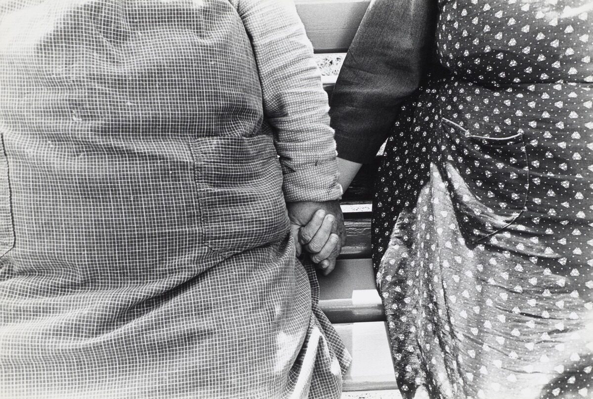 Schwarz-Weiss-Fotografie von zwei vermutlich älteren Frauen, die sich an der Hand halten. Es handelt sich dabei um eine Aufnahme aus dem Alters- und Pflegeheim in Utzigen, 1971/1972.