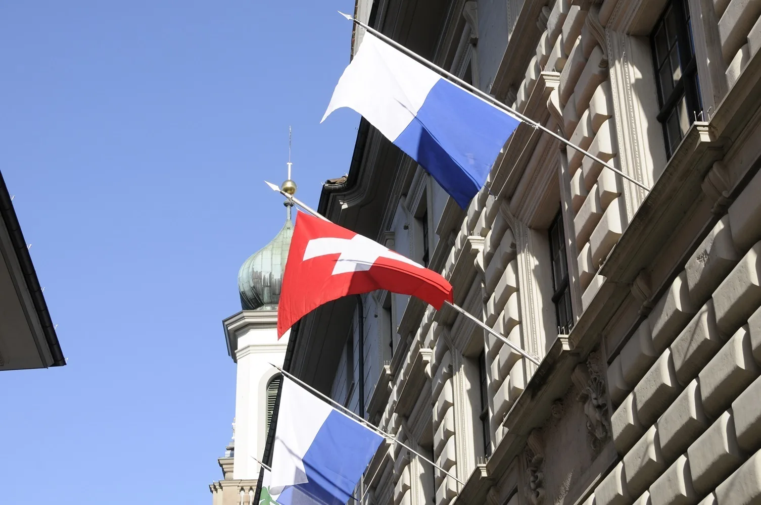 Luzerner Regierungsgebäude mit Schweizer Fahne und Luzerner Fahne